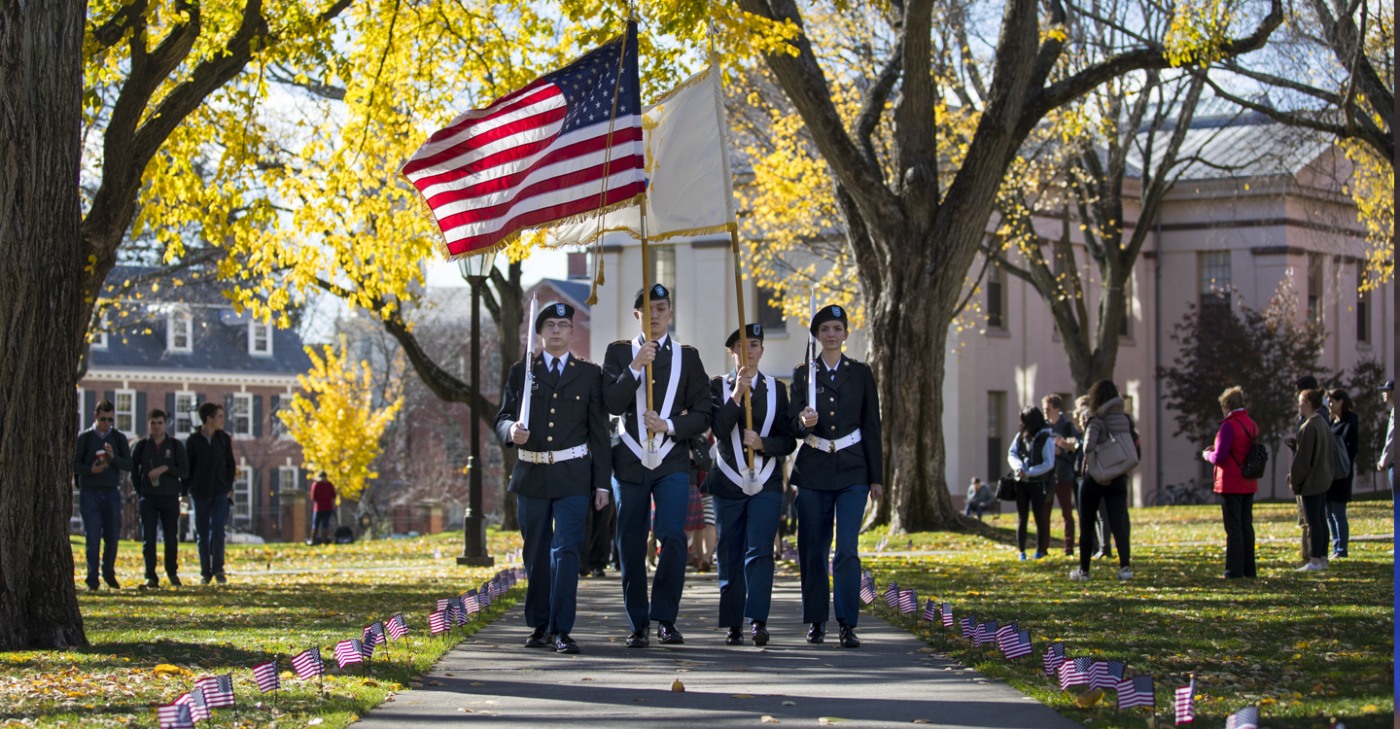 Veterans carrying flags during Veterans Day ceremonies on the main green.
