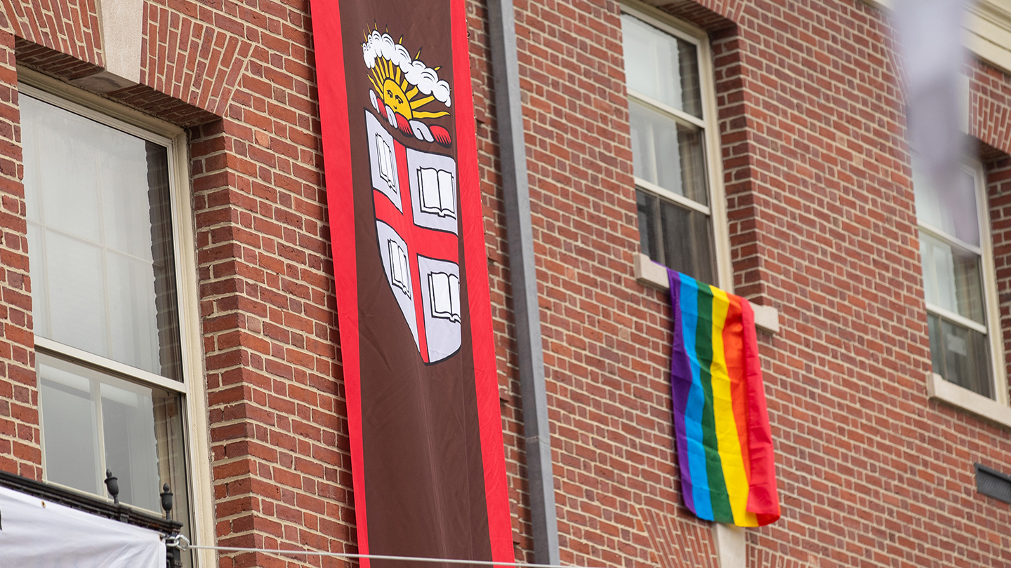Brown seal banner and rainbow flag hanging next to each other