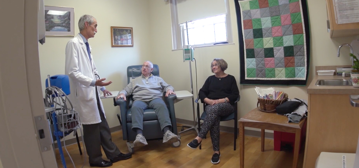 Dr. Stephen Salloway talking with two patients in an exam room