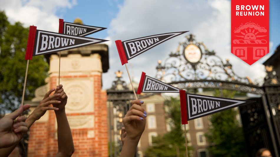 Students holding pennants in front of the Van Wickle Gates.