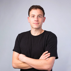 Toby Espinosa wearing a black shirt against a gray background.